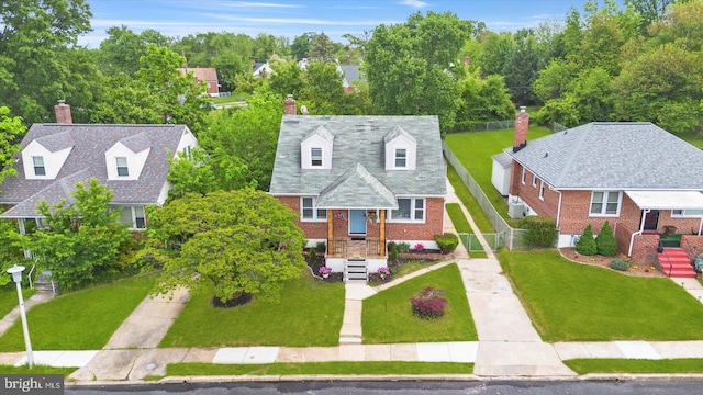 view of front of property with brick siding, a chimney, and concrete driveway