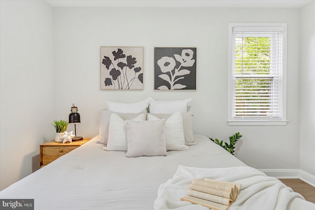 bedroom featuring baseboards and wood finished floors