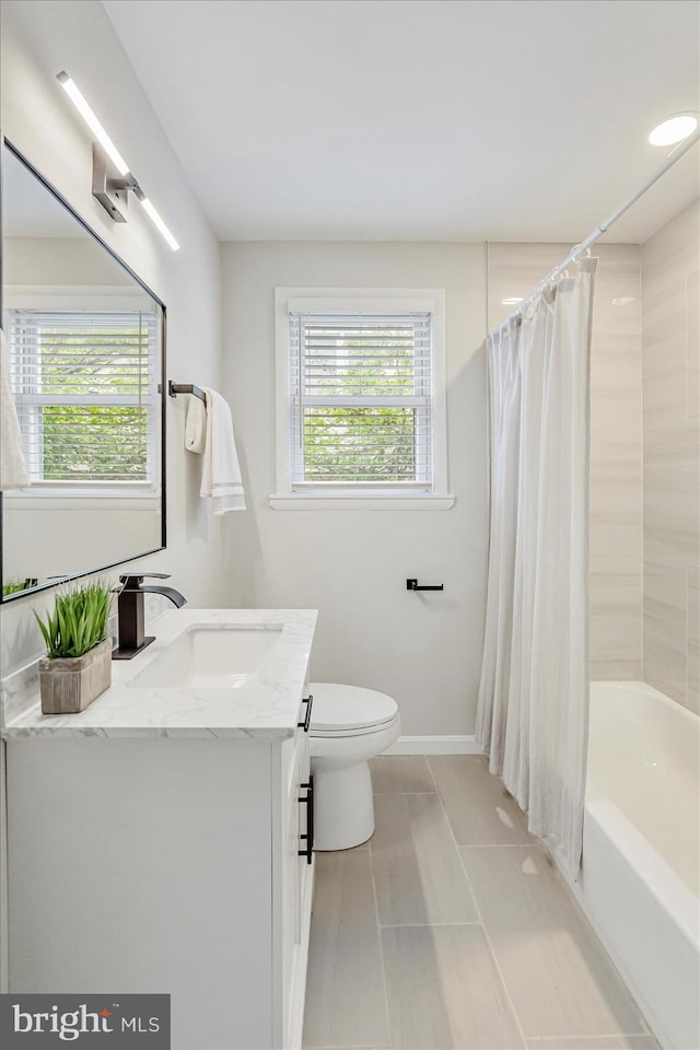 full bathroom with toilet, vanity, shower / bathtub combination with curtain, and baseboards