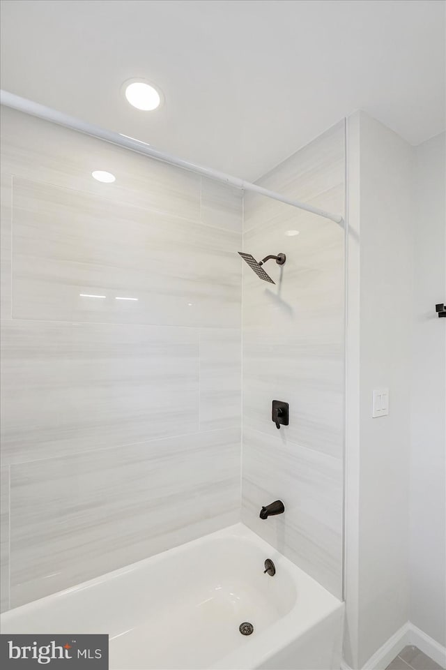 full bathroom with washtub / shower combination and baseboards