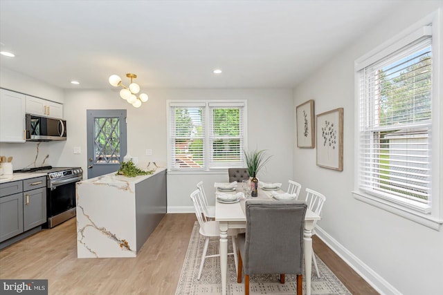 dining area featuring light wood-style floors, baseboards, and recessed lighting