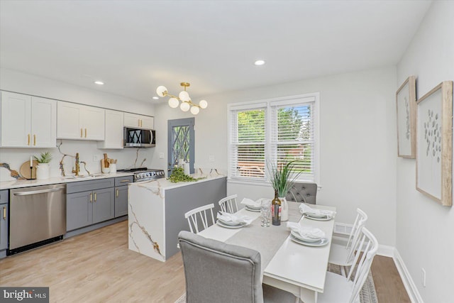dining room featuring light wood finished floors, recessed lighting, and a chandelier