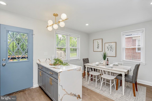 kitchen featuring gray cabinetry, light wood finished floors, light stone countertops, baseboards, and recessed lighting