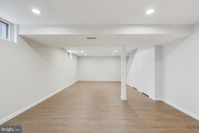 basement with baseboards, wood finished floors, recessed lighting, and stairs