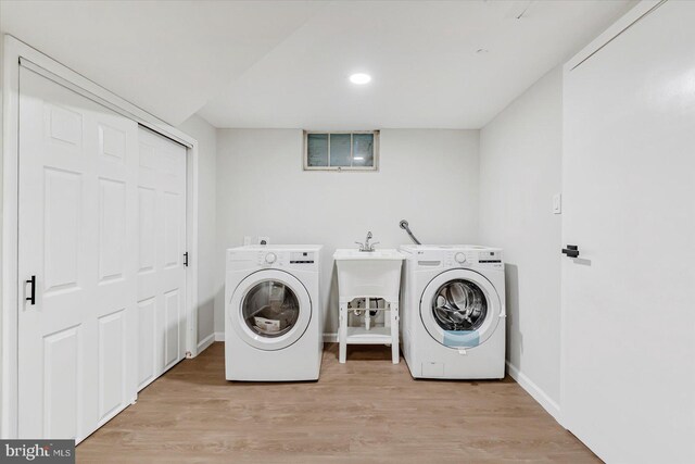 laundry area featuring independent washer and dryer, light wood-style flooring, baseboards, and recessed lighting