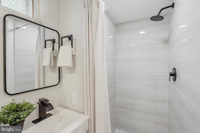 full bathroom with a tile shower and a sink