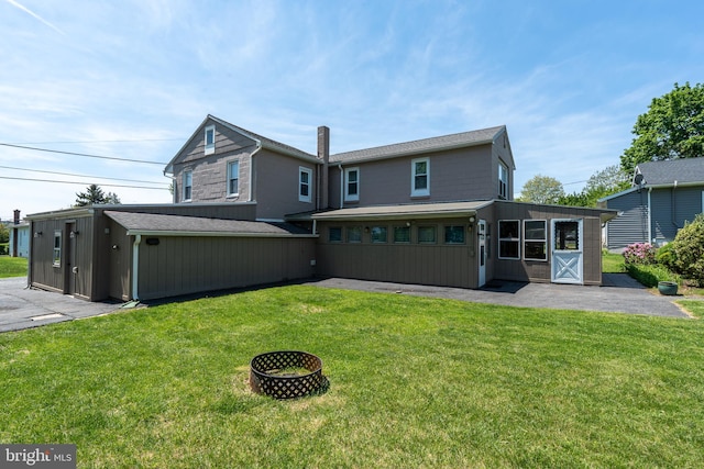 334 Windsor St, Wyomissing, PA 19610 - back of property with a yard, a patio area, and board and batten siding