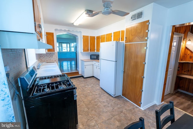 334 Windsor St, Wyomissing, PA 19610 - kitchen featuring range with gas stovetop, freestanding refrigerator, black microwave, a sink, and arched walkways