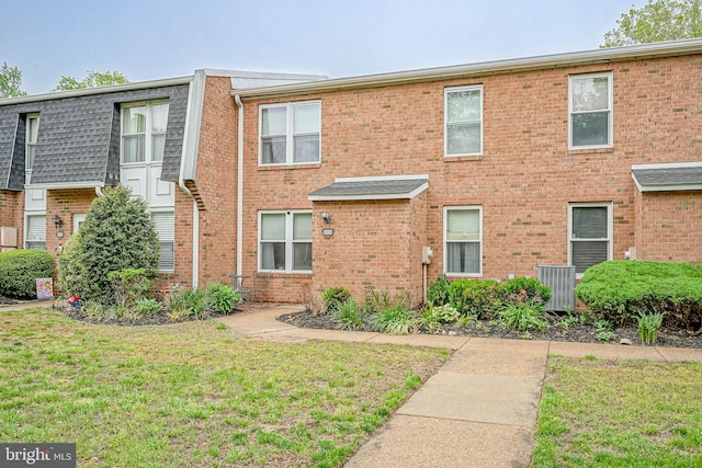 multi unit property with a front yard and brick siding