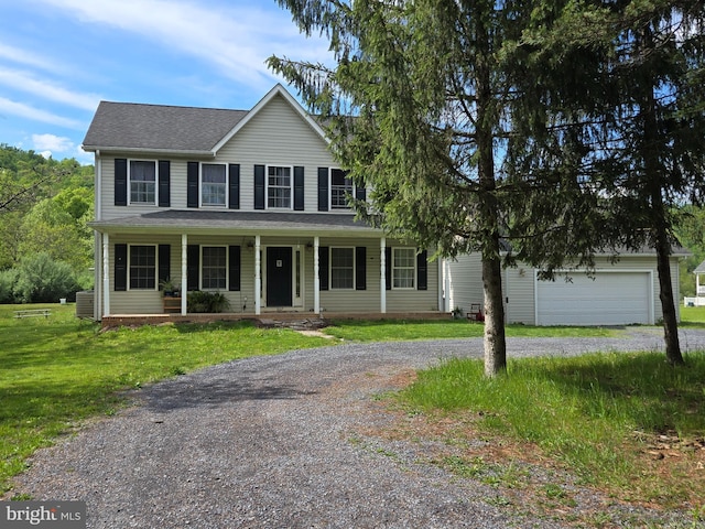 colonial inspired home featuring driveway, a porch, a front yard, and a shingled roof