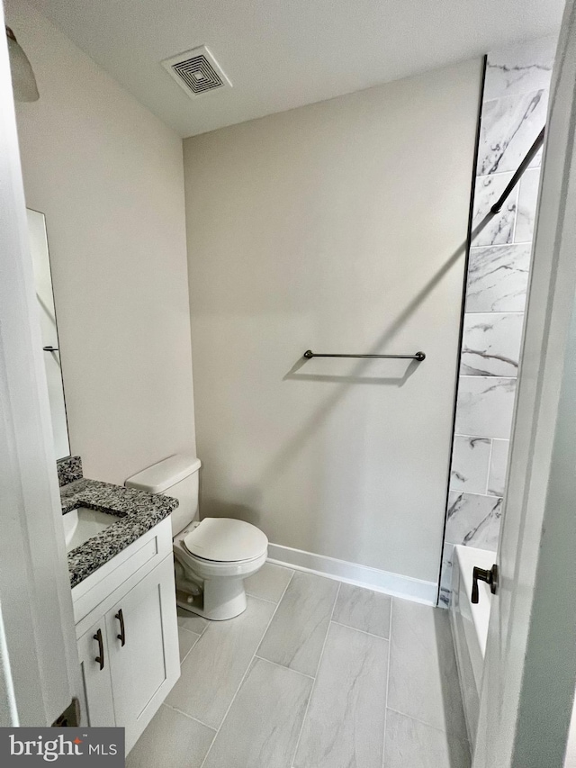 826 S Glebe Rd, Montross, VA 22520 - bathroom featuring marble look tiles, vanity, toilet, and baseboards