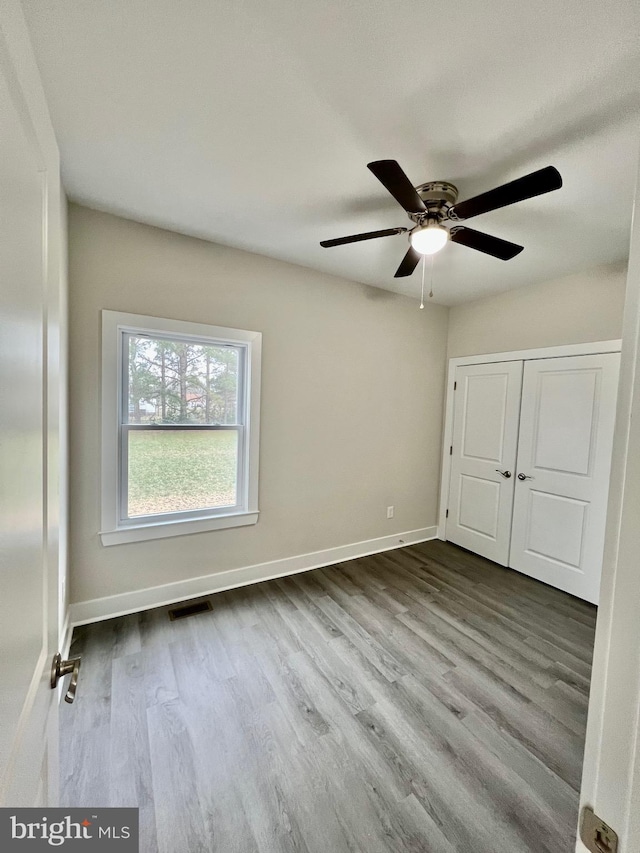 826 S Glebe Rd, Montross, VA 22520 - unfurnished bedroom with dark wood-type flooring, baseboards, ceiling fan, and a closet