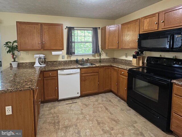 106 Perth Amboy Ct, Upper Marlboro, MD 20774 - kitchen with black appliances, brown cabinetry, a sink, a textured ceiling, and dark stone counters