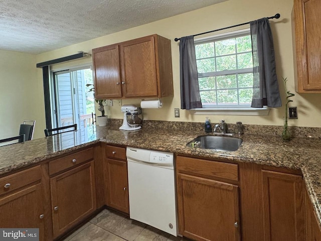 106 Perth Amboy Ct, Upper Marlboro, MD 20774 - kitchen with white dishwasher, a sink, brown cabinetry, a textured ceiling, and a peninsula