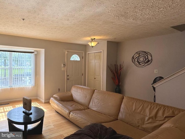 106 Perth Amboy Ct, Upper Marlboro, MD 20774 - living room with light wood-style floors, plenty of natural light, baseboards, and a textured ceiling