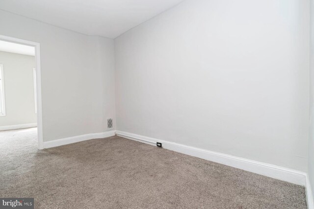 unfurnished room with carpet and baseboards