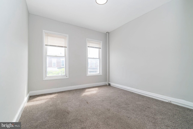 empty room with healthy amount of natural light, carpet floors, and baseboards