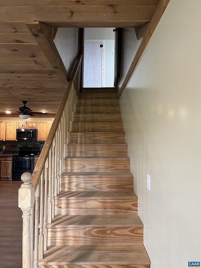 stairway featuring wood finished floors and ceiling fan