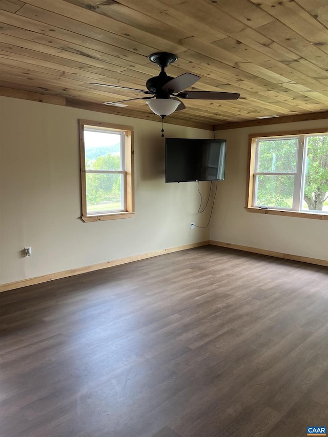 empty room with wooden ceiling, plenty of natural light, wood finished floors, ceiling fan, and baseboards