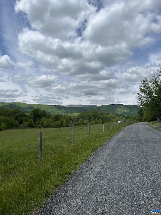 view of asphalt road with a rural view