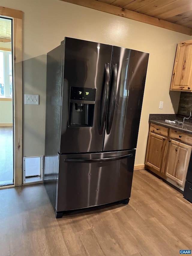 kitchen with black fridge with ice dispenser, light wood finished floors, wood ceiling, and baseboards