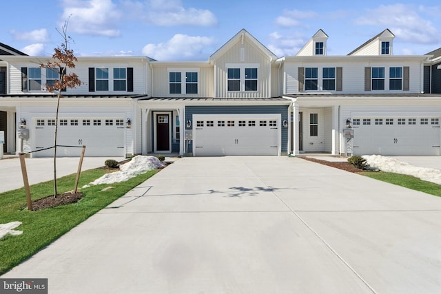 multi unit property featuring a garage, driveway, and board and batten siding