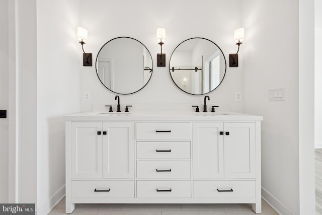 full bath featuring baseboards and double vanity