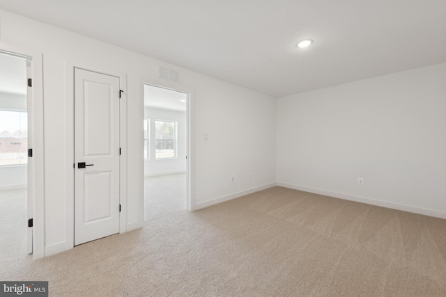 unfurnished room featuring light carpet, baseboards, and recessed lighting