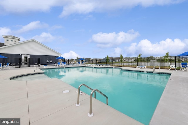 community pool with fence and a patio