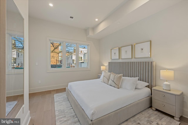 bedroom with light wood finished floors, baseboards, and recessed lighting