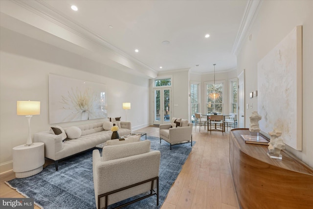 living room with crown molding, light wood-style floors, recessed lighting, baseboards, and a chandelier