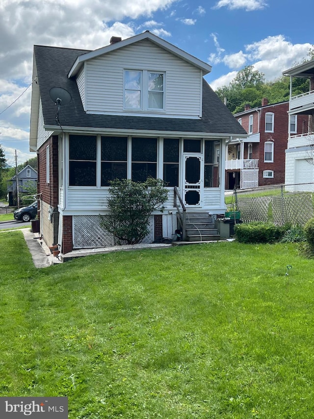 view of front of property with a shingled roof, a sunroom, and brick siding
