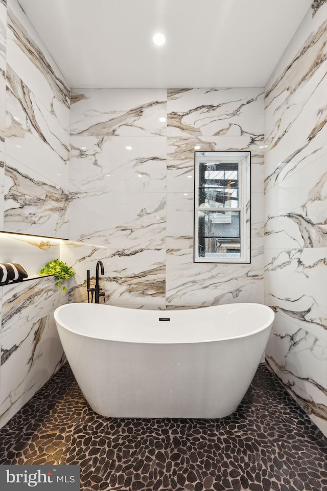 728 S Warnock St, Philadelphia, PA 19147 - bathroom with stone wall, a soaking tub, and recessed lighting