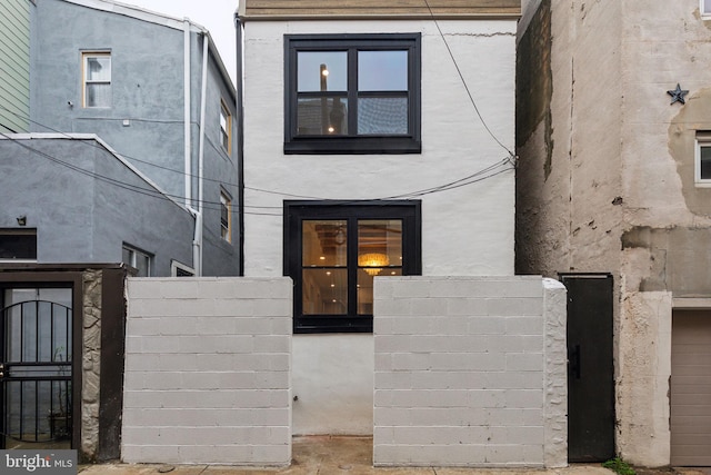 728 S Warnock St, Philadelphia, PA 19147 - view of front of house featuring stucco siding, fence, and a gate