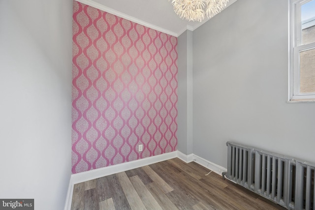1321 Wolf St, Philadelphia, PA 19148 - unfurnished room featuring radiator, baseboards, crown molding, dark wood-type flooring, and a chandelier