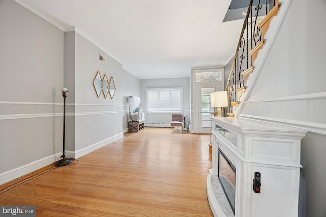 1321 Wolf St, Philadelphia, PA 19148 - entrance foyer featuring light wood finished floors, ornamental molding, stairway, baseboards, and a baseboard heating unit
