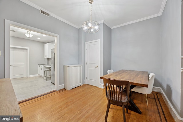 1321 Wolf St, Philadelphia, PA 19148 - dining room with a chandelier, light wood-type flooring, ornamental molding, and baseboards