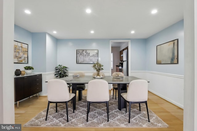 dining area with light wood finished floors and recessed lighting