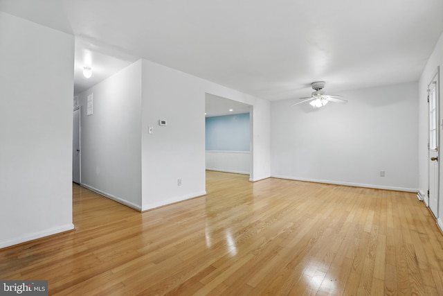 unfurnished living room with a ceiling fan, light wood-type flooring, and baseboards