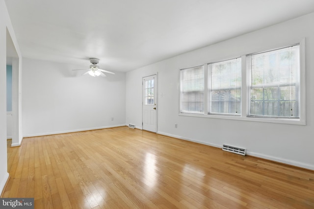 unfurnished living room featuring light wood-style floors, a ceiling fan, and baseboards