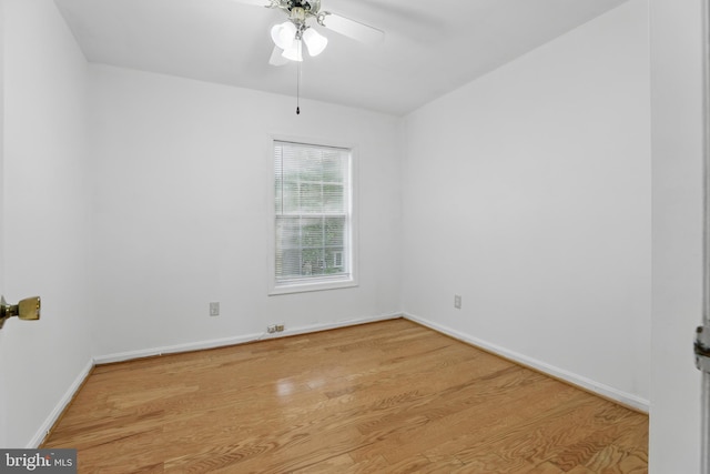 unfurnished room with wood finished floors, a ceiling fan, and baseboards