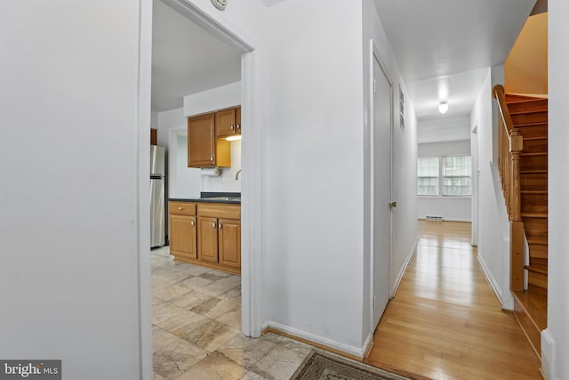 hallway with stairs and baseboards