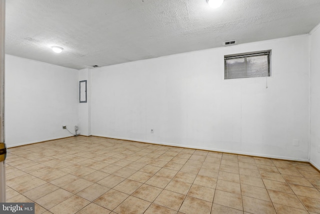 finished below grade area featuring a textured ceiling