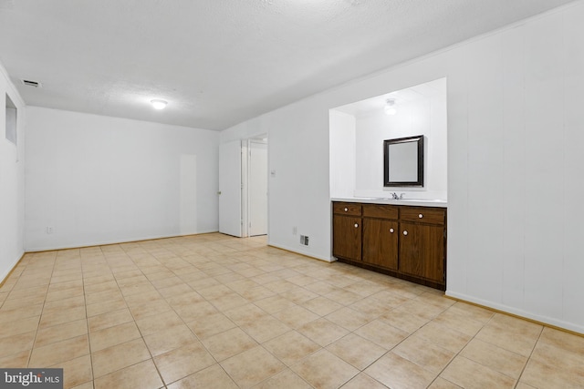 spare room featuring a sink and baseboards