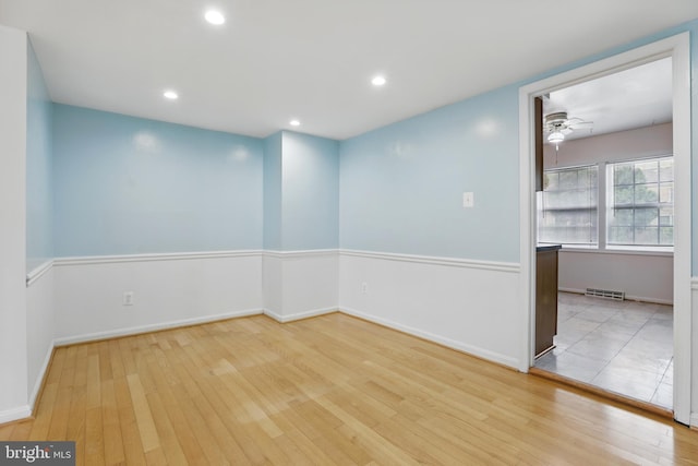spare room with light wood-type flooring, a ceiling fan, baseboards, and recessed lighting
