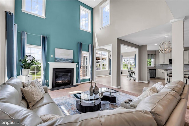 308 Galloway St, Middletown, DE 19709 - living room featuring a high ceiling, plenty of natural light, a fireplace with flush hearth, a chandelier, and ornate columns
