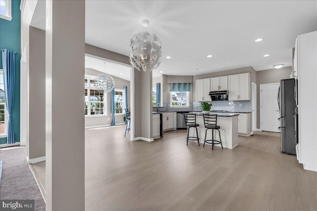 308 Galloway St, Middletown, DE 19709 - kitchen featuring a chandelier, appliances with stainless steel finishes, white cabinetry, light wood-style floors, and a breakfast bar area