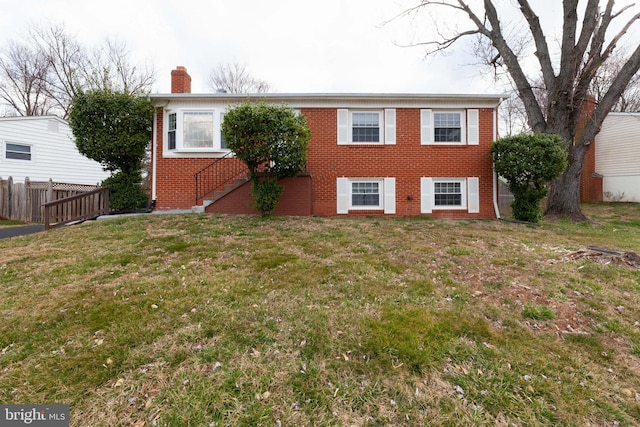 view of front of home featuring a chimney, brick siding, and stairs