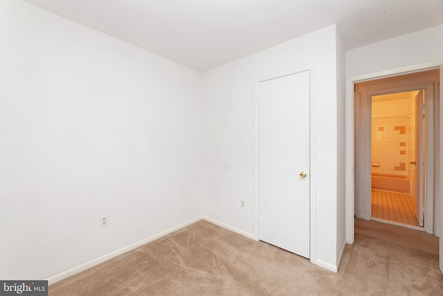 unfurnished bedroom with light carpet and baseboards