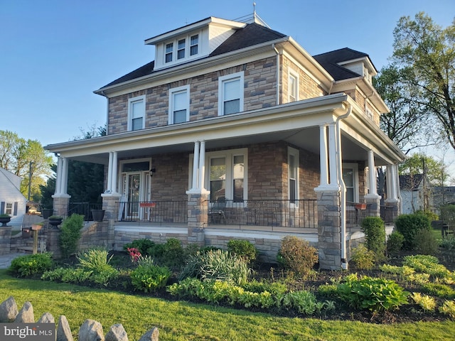 traditional style home with stone siding and covered porch